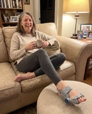 A woman relaxing on the couch wearing the Kindtoe Dial